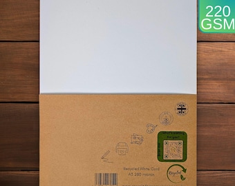 Könnte beinhalten: Ein Stapel Papier im A3-Format mit einem weißen obersten Blatt und einem braunen Umschlag aus Recyclingkarton. Der Umschlag enthält einen QR-Code, den Text 'Recycled White Cord A3 280 micron', einen Strichcode und kleine Liniengrafiken.