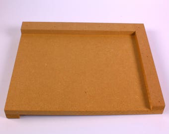 May include: An unfinished wooden tray, rectangular in shape, with raised edges. Constructed from light brown particle board, it features a simple, functional design. The edges are thicker than the base, creating a defined border.
