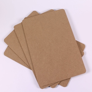 Op de afbeelding: Een stapel van vier bruine kartonnen vellen, waarschijnlijk voor knutselen of scrapbooking.