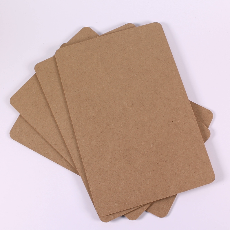 Op de afbeelding: Een stapel van vier bruine kartonnen vellen, waarschijnlijk voor knutselen of scrapbooking.