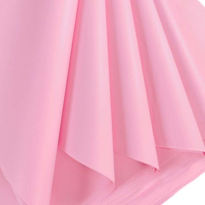 May include: Pink tissue paper folded in a fan shape. The paper is soft and delicate, perfect for wrapping gifts or adding a touch of color to your crafts.