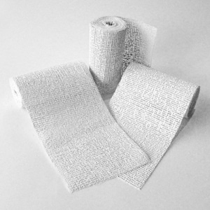 May include: Three rolls of white plaster bandage, a medical supply used for setting broken bones.