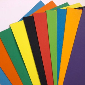May include: A fan of ten different coloured cardstock paper sheets. The colours are orange, green, yellow, black, red, green, blue, orange, purple, and blue.