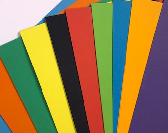 Könnte beinhalten: Ein Fächer aus zehn verschiedenenfarbigen Kartonbögen. Die Farben sind orange, grün, gelb, schwarz, rot, grün, blau, orange, lila und blau.