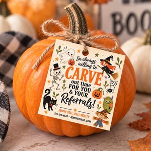 Op de afbeelding: Een feloranje pompoen met een vierkant papieren label dat met touw aan de steel is bevestigd. Het label bevat Halloween-illustraties van een geest, skelet, heks, kat, spin, pompoen, monster en vogelverschrikker, met de tekst: I'm always willing to CARVE out time FOR YOU & YOUR REFERRALS! JENNY BELL, BELL REALTY 515-123-4567 JENNY@EMAIL.COM.