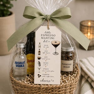 Op de afbeelding: Een cadeaupakket voor een espresso martini, met wodka, koffielikeur, een potje koffiebonen en een receptkaart. Het pakket is verpakt in cellofaan en afgewerkt met een groene strik.