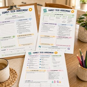 May include: Three printed sheets titled Family Tech Agreement with sections for values, rules, and screen time plans. The documents feature colorful icons, checkboxes, and lines for writing, presented on a wooden table with a mug and pencils.