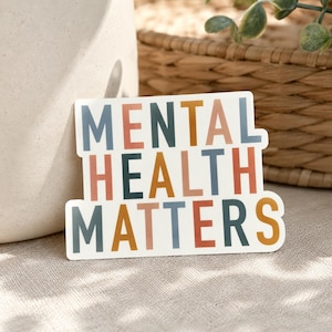 May include: A rectangular white sticker featuring the phrase "MENTAL HEALTH MATTERS" in a bold, colourful font. The text uses shades of blue, orange, pink, and green. The sticker has a modern, minimalist aesthetic.