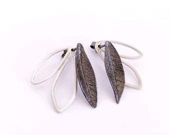 May include: A pair of silver earrings with a delicate leaf design. The leaves are textured and have a dark oxidized finish.