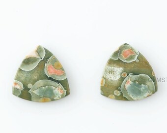 May include: Two triangular green, white, and orange patterned gemstone cabochons.