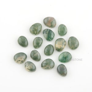 Pode incluir: Uma cole&ccedil;&atilde;o de 15 caboch&otilde;es de &aacute;gata verde musgo, cada um com um padr&atilde;o &uacute;nico de verde, branco e marrom. Os caboch&otilde;es s&atilde;o de forma oval e t&ecirc;m um acabamento liso e polido.