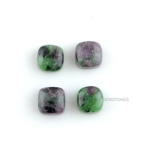 May include: Four square-shaped green and purple gemstones with a speckled pattern.