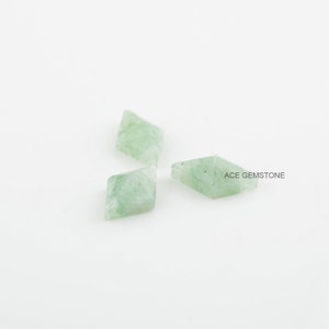 May include: Three light green gemstone beads in a diamond shape. ACE GEMSTONE is printed on the white background.