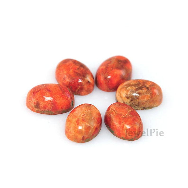 Puede incluir: Seis cabujones ovalados de piedra preciosa roja y marr&oacute;n. Los cabujones son lisos y pulidos.