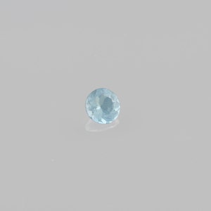 May include: A light blue round gemstone with facets.