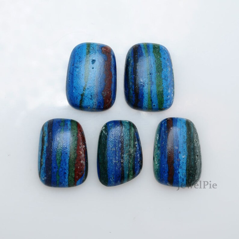 May include: Five blue, green, and red striped cabochon stones. The stones are smooth and polished.