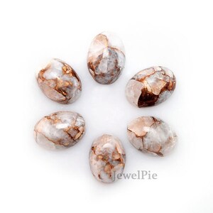 May include: Six oval-shaped, white and brown, natural gemstone cabochons. The stones have a marbled pattern with brown veins and swirls.