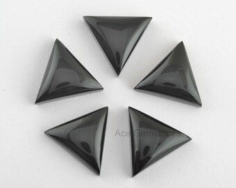 May include: Five black triangle-shaped gemstone cabochons, each with a smooth, polished surface. The cabochons are arranged in a starburst pattern on a white background.