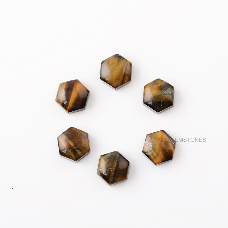 May include: Six hexagonal tiger's eye cabochons, each with a unique pattern of brown and gold.