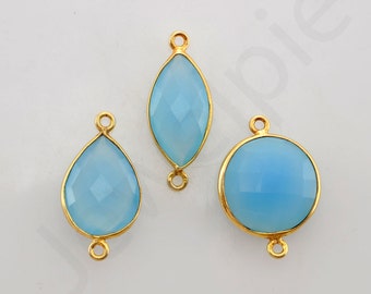 May include: Three gold-toned metal connector charms with light blue gemstone accents. The charms are in the shapes of a teardrop, oval, and circle.