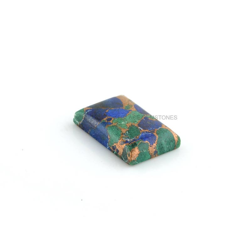 May include: A rectangular, green, blue, and copper-colored gemstone with a marbled pattern.