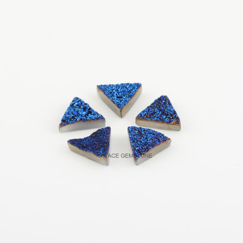 May include: Five blue and gold triangular agate cabochons, each with a unique pattern of sparkling crystals.