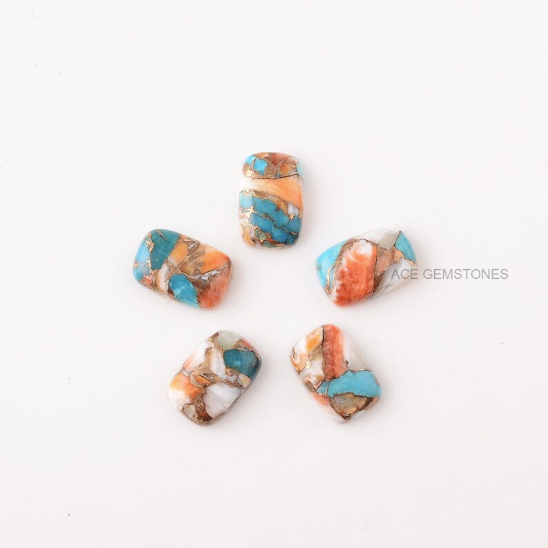 Puede incluir: Seis cabujones rectangulares de turquesa, naranja y blanco con motas doradas. ACE GEMSTONES est&aacute; impreso en la esquina inferior derecha de la imagen.