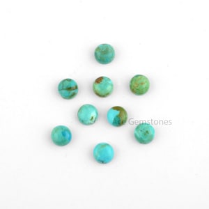 May include: Ten round turquoise cabochons, each with a unique pattern of green and blue, are arranged in a loose circle on a white background.