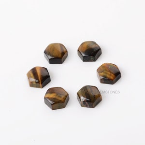 May include: Six hexagonal cabochon gemstones with a tiger's eye pattern in shades of brown and gold.