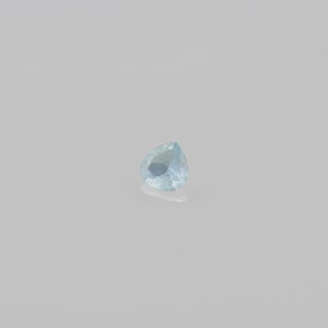 May include: A light blue pear-shaped gemstone with a faceted cut.