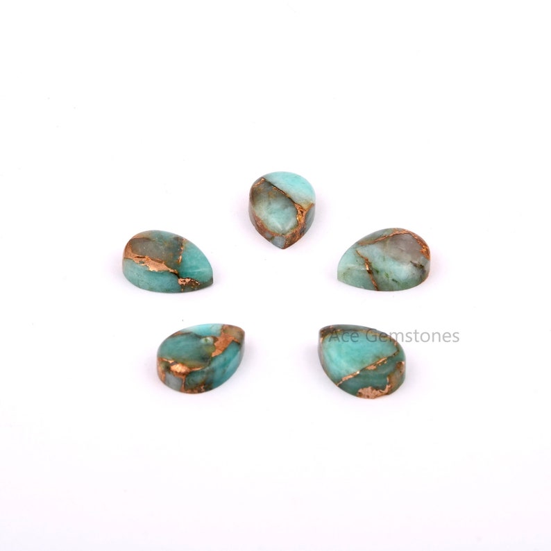 May include: Five teardrop-shaped cabochons of green amazonite with copper inclusions. The stones are polished and have a smooth, glossy finish.
