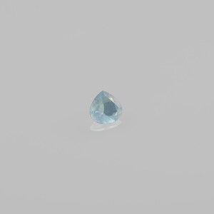 May include: A teardrop-shaped gemstone with a light blue color.