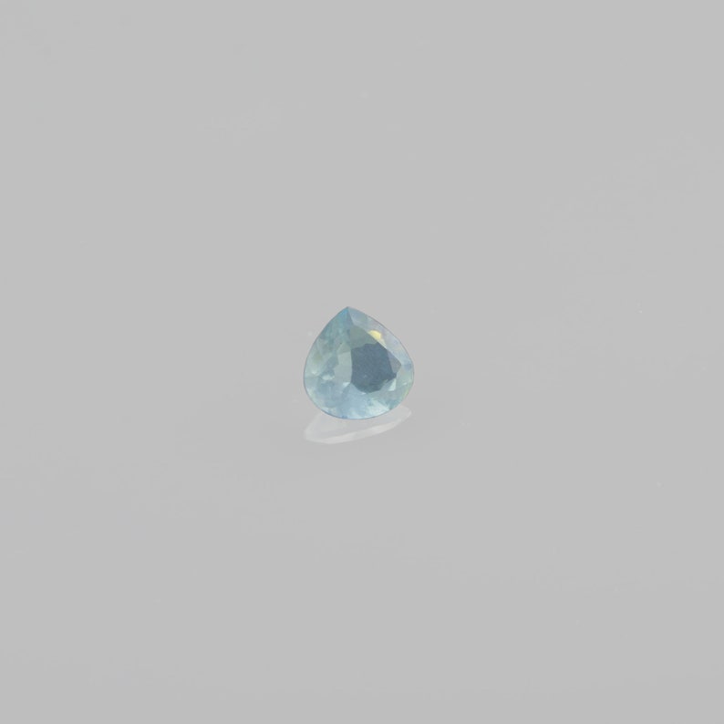 May include: A teardrop-shaped gemstone with a light blue color.