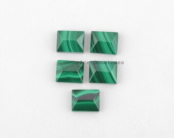 May include: Five green malachite gemstone cabochons in a rectangular shape with beveled edges. The stones have a green and black marbled pattern.