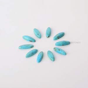 May include: A collection of eleven oval-shaped turquoise gemstones arranged in a circular pattern. The stones have a polished finish with brown veining, set against a white background. The text "ACE GEMSTONES" is visible in the image.