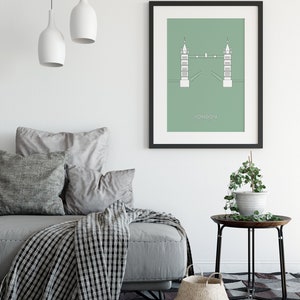 May include: A framed print of a minimalist line drawing of the Tower Bridge in London, with a green background and the word "LONDON" printed below the bridge.