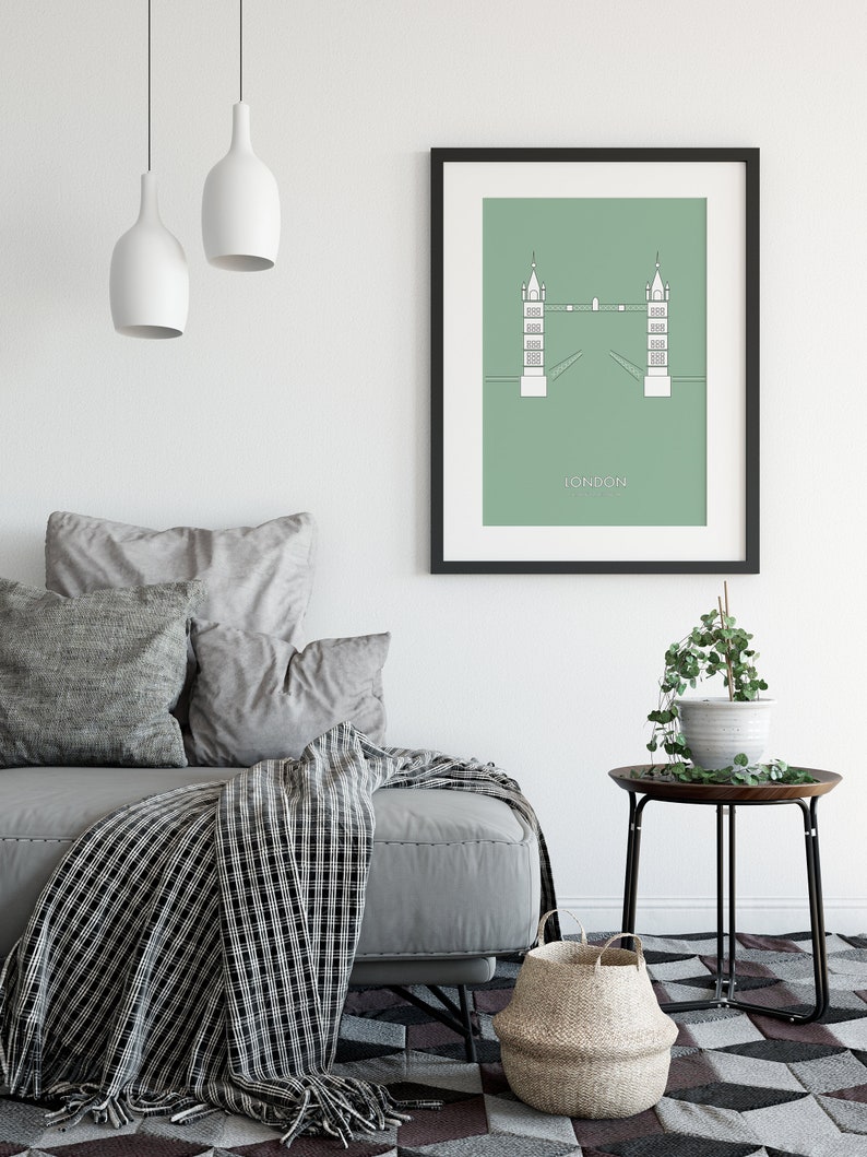 May include: A framed print of a minimalist line drawing of the Tower Bridge in London, with a green background and the word "LONDON" printed below the bridge.