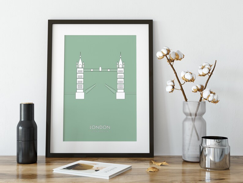 May include: A framed print of a minimalist illustration of the Tower Bridge in London, with a green background and the word "LONDON" printed below the bridge.