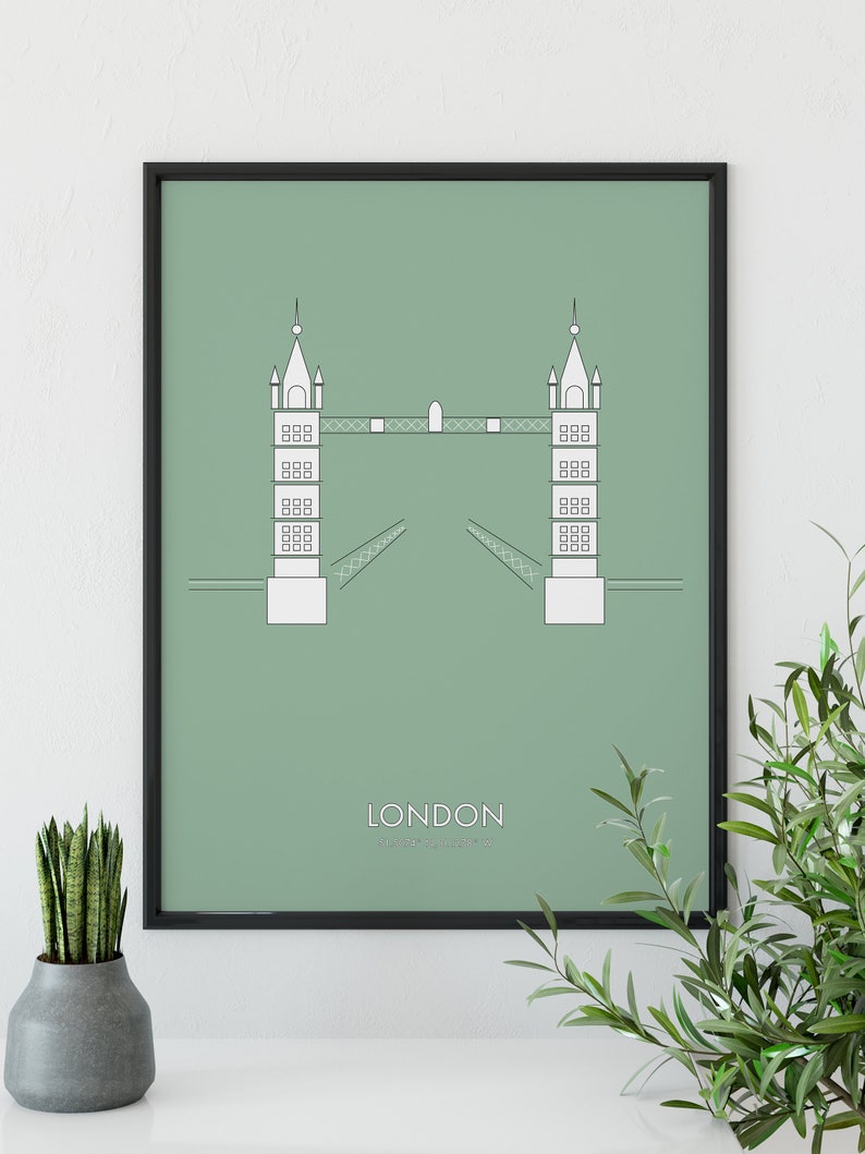 May include: A framed print with a minimalist line drawing of the Tower Bridge in London on a sage green background. The text "LONDON" and "Tower Bridge" is printed below the image.