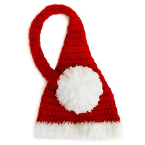 Pu&ograve; includere: Cappello di Babbo Natale rosso all'uncinetto con un pon pon bianco in cima e un bordo di pelliccia bianca intorno al fondo.