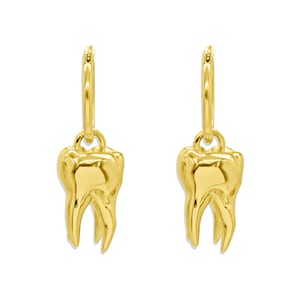 May include: A pair of gold-colored earrings, each featuring a detailed molar pendant suspended from a small hoop. The earrings have a polished, reflective surface, and the molar design showcases the tooth's natural shape.