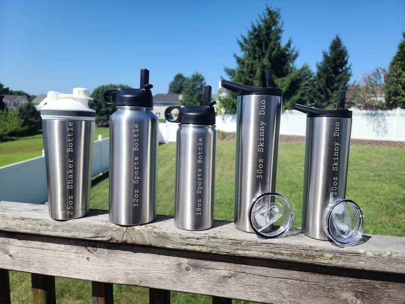 May include: Five stainless steel water bottles with different sizes and labels. The bottles are arranged from left to right: 25oz Shaker Bottle, 32oz Sports Bottle, 18oz Sports Bottle, 30oz Skinny Duo, 20oz Skinny Duo.