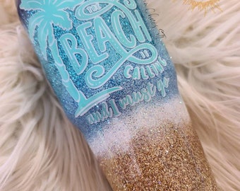 May include: A blue and gold glitter tumbler with a palm tree and the text "The Beach is Calling and I Must Go".