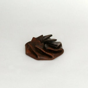 May include: A brown leather coin purse folded into a flower shape.