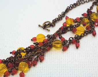 Antiqued brass chain necklace with yellow and red glass bead dangles (25 inches long)