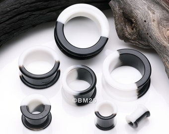 A Pair of Black and White Duo Tone Flexible Silicone Double Flared Tunnel Plug