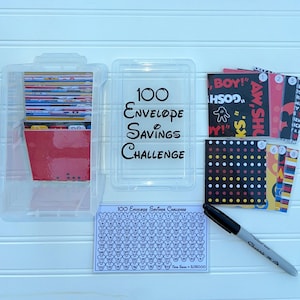 May include: A clear plastic container with 100 red envelopes inside. The container has a label that says "100 Envelope Savings Challenge". There are also eight colorful cards with Mickey Mouse characters and numbers 1 through 8. A black marker and a sheet of paper with 100 Mickey Mouse heads are also visible.