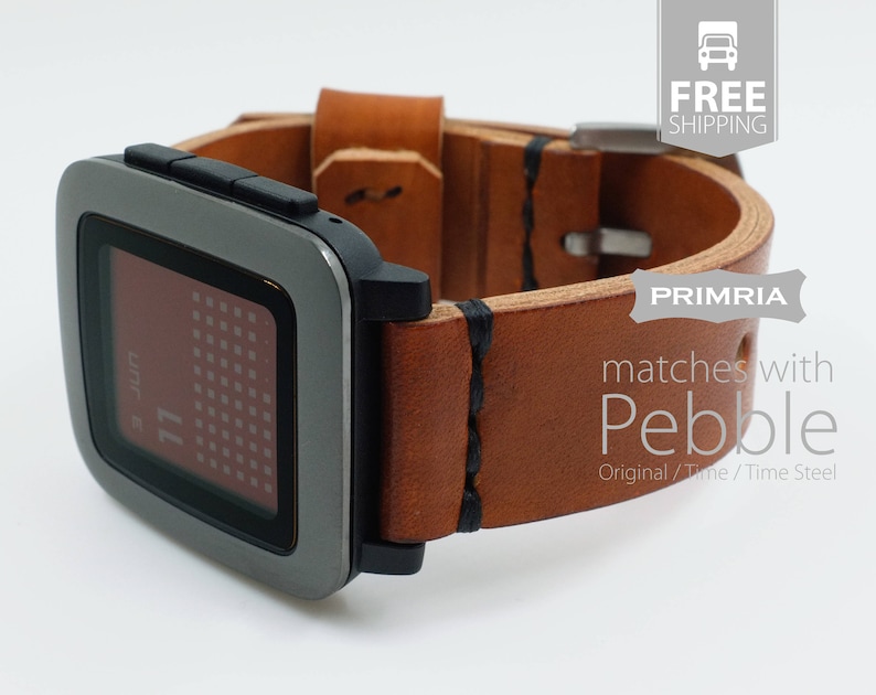 K&ouml;nnte beinhalten: Ein braunes Lederarmband mit schwarzen N&auml;hten, das f&uuml;r eine Pebble Smartwatch konzipiert ist. Das Armband ist an einer Pebble Smartwatch mit einem grauen Metallgeh&auml;use und einem schwarzen Bildschirm, auf dem ein Kalender angezeigt wird, befestigt.