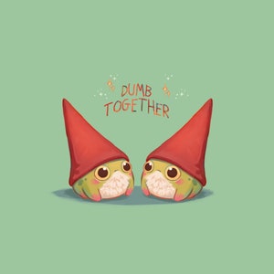 May include: Two green frog gnomes wearing red pointed hats with the text "DUMB TOGETHER" above them.