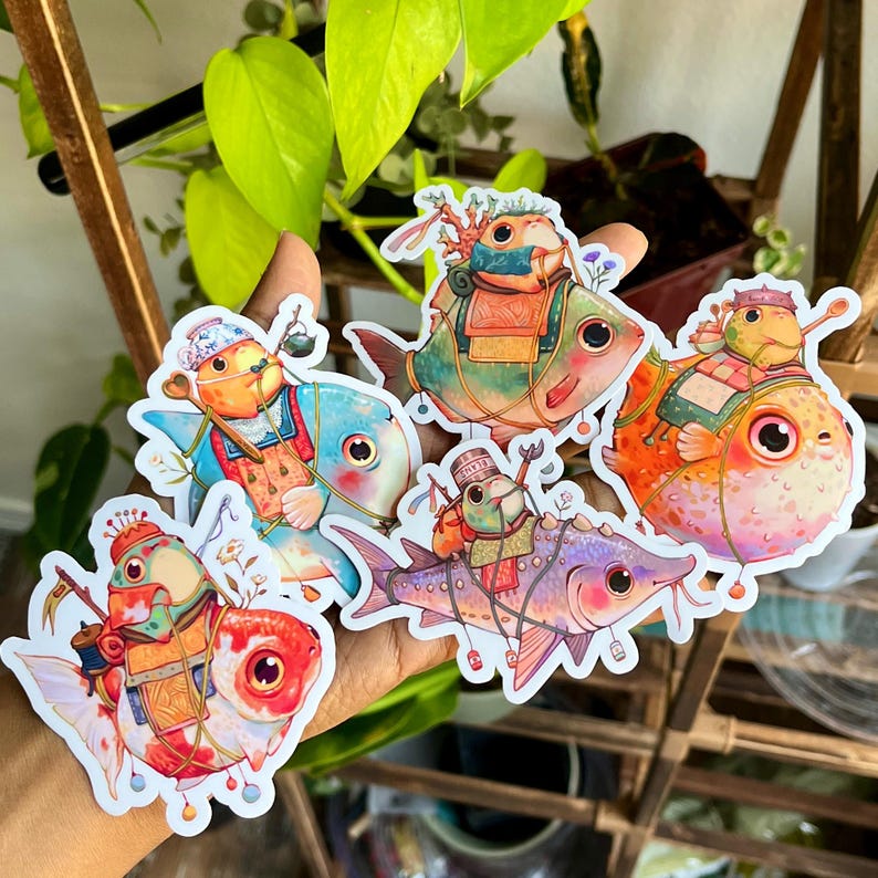 May include: A collection of colorful fish stickers, each adorned with unique outfits and accessories. The stickers feature a variety of fish species in shades of blue, orange, red, and purple, with detailed illustrations and whimsical designs.